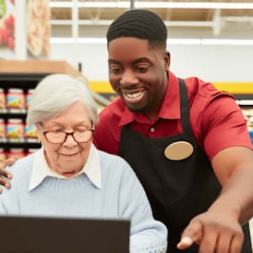 Senior woman receiving assistance with online grocery shopping at Food Lion
